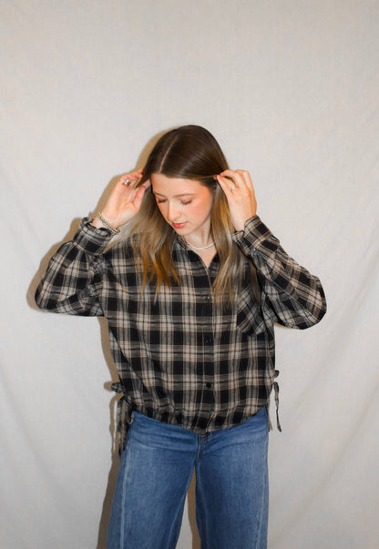 Person wearing a plaid shirt and jeans against a plain background