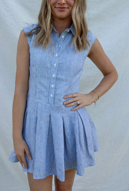 Woman wearing a blue checkered dress against a plain background