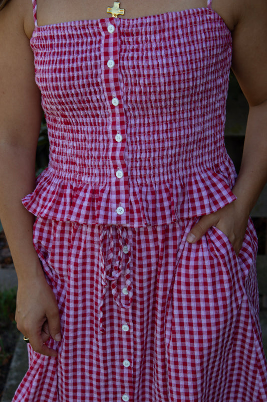 Red and white checkered dress with buttons on a blurred background