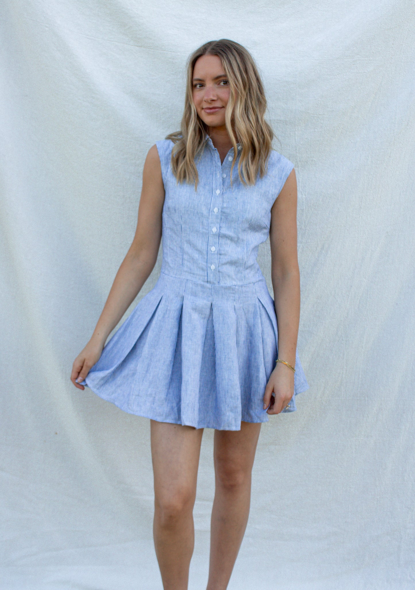 Woman wearing a light blue checkered dress against a white background