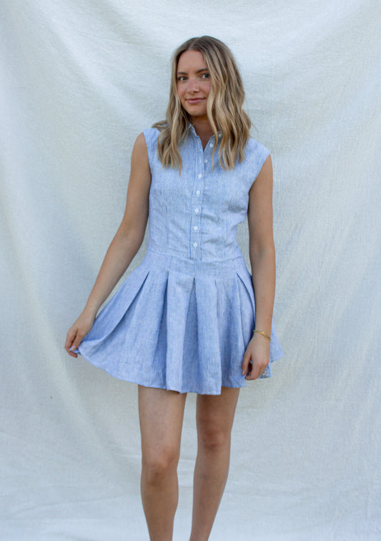 Woman wearing a light blue checkered dress against a white background