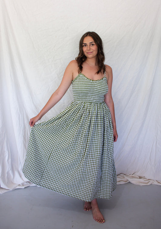 Woman wearing a green checkered dress against a white background