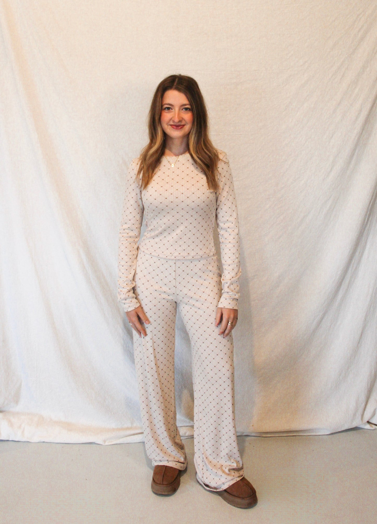 Woman wearing a matching polka dot pajama set against a white background