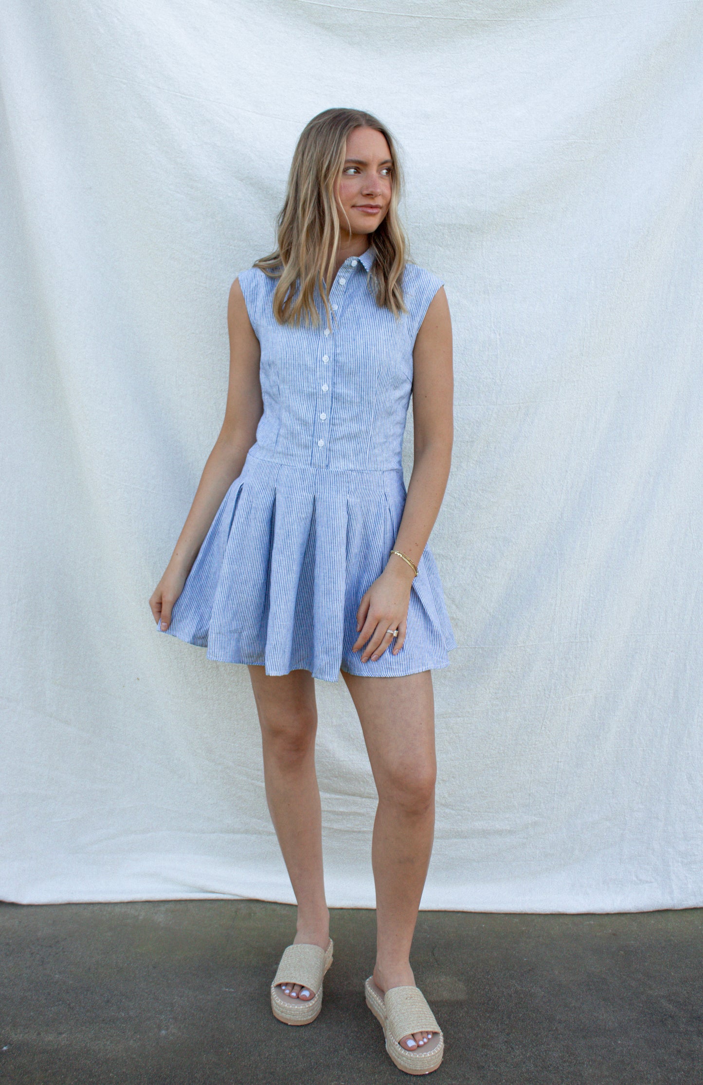 Woman wearing a light blue dress against a white background