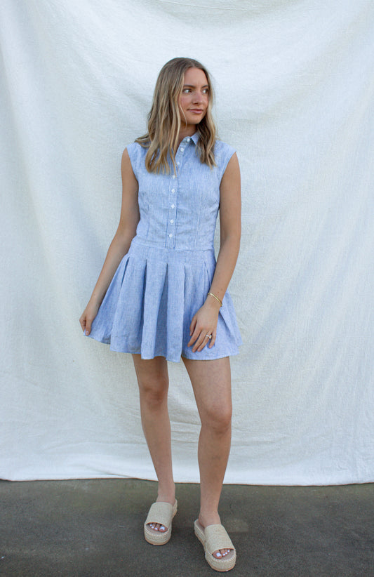 Woman wearing a light blue dress against a white background