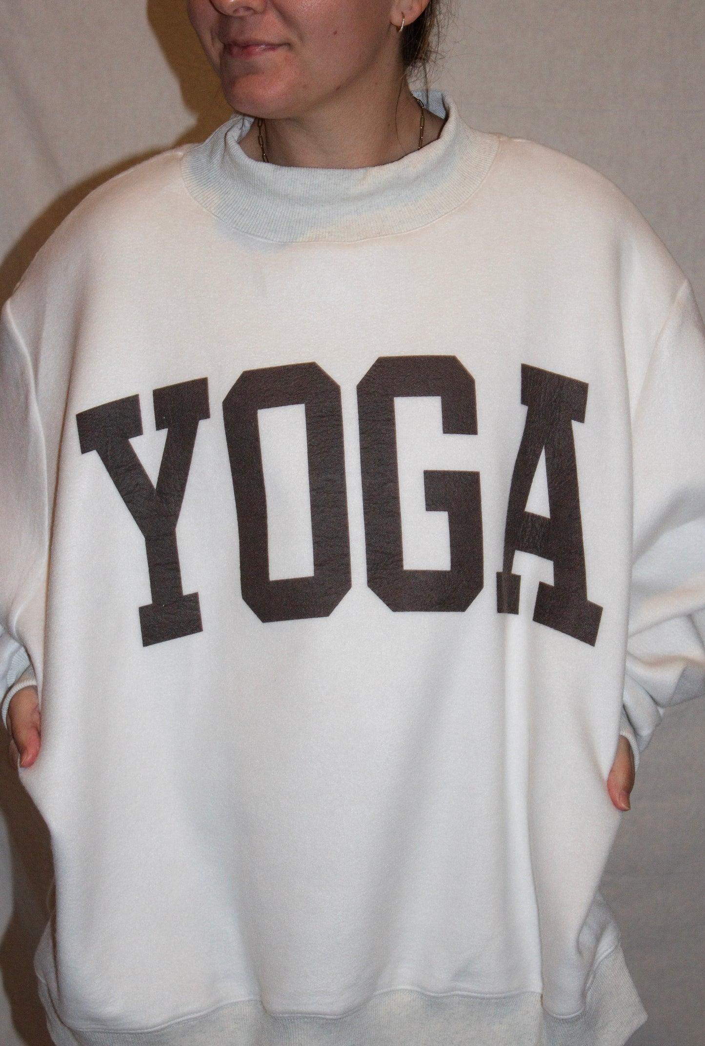 Person wearing a gray sweatshirt with 'YOGA' printed on it.