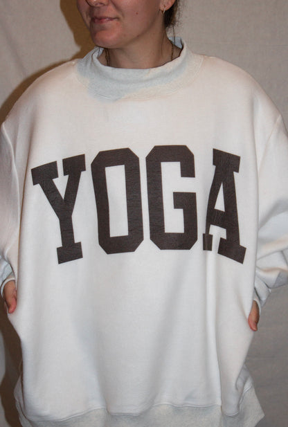 Person wearing a gray sweatshirt with 'YOGA' printed on it.