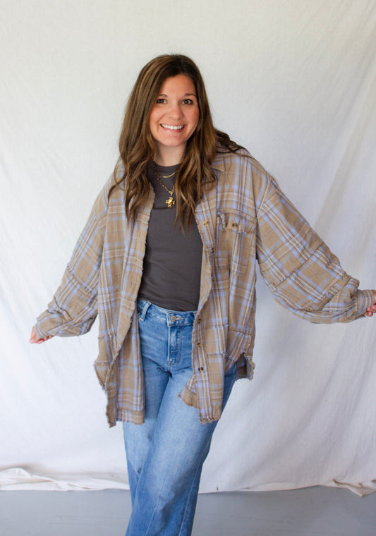 Woman wearing a plaid shirt and jeans against a white background