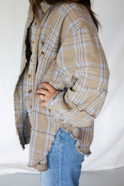 Person wearing a plaid shirt and blue jeans on a white background