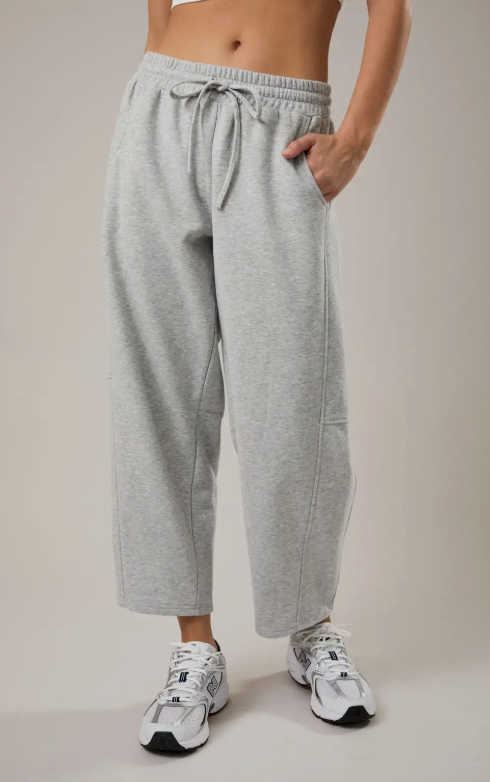 Person wearing gray sweatpants with a neutral background